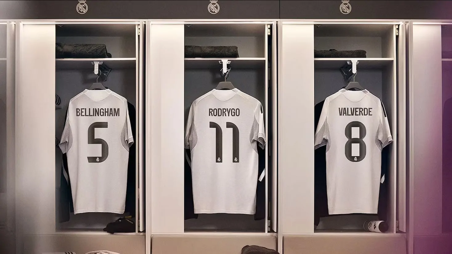Collection of official 2025-26 soccer kits in a professional locker room.