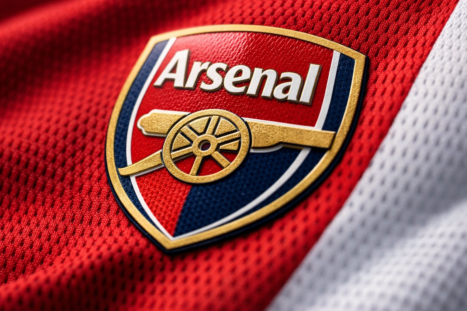 Close-up of the heat-pressed crest and fabric on an authentic Arsenal jersey.