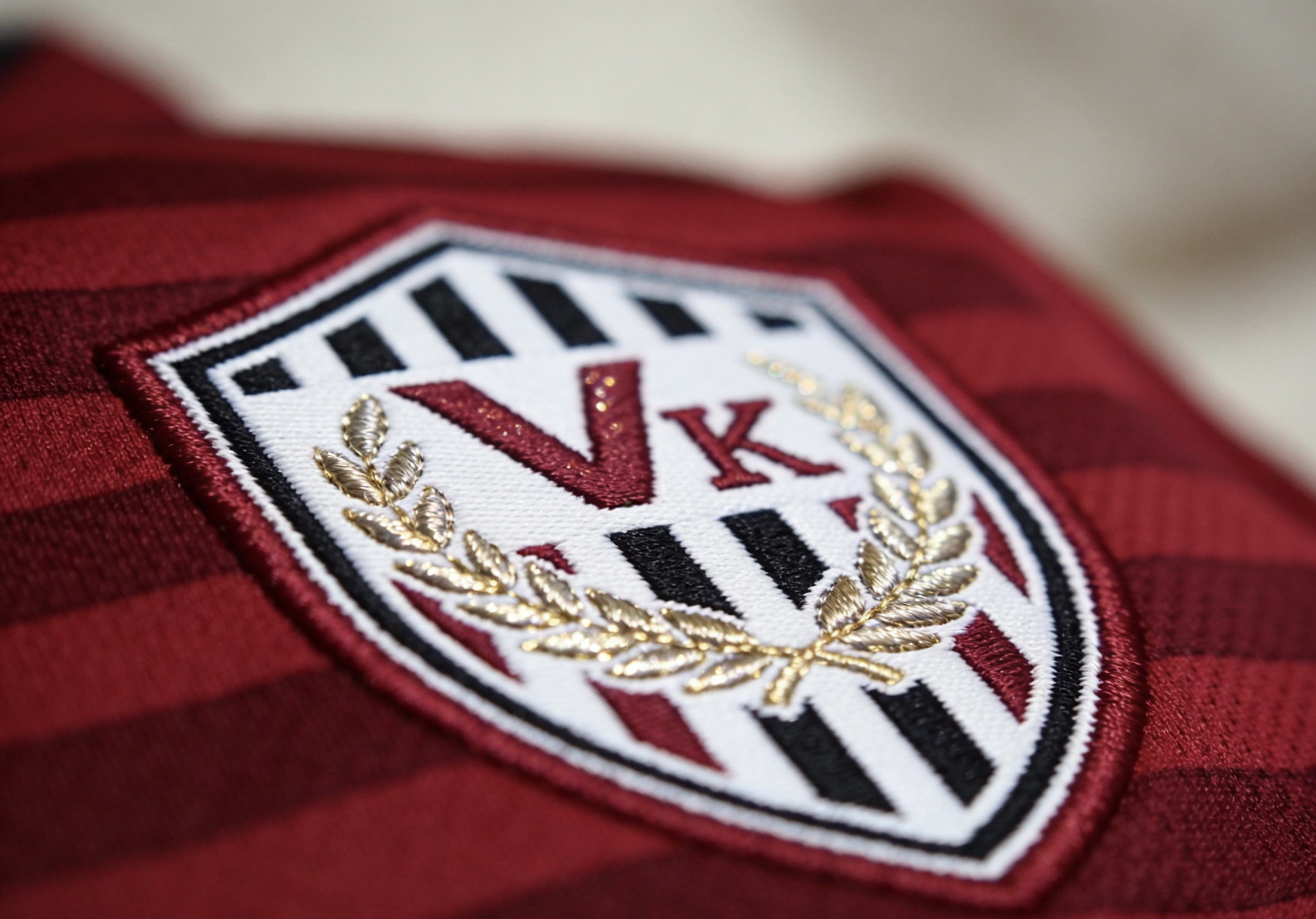 Close-up detail of the Vissel Kobe soccer jersey badge and fabric.